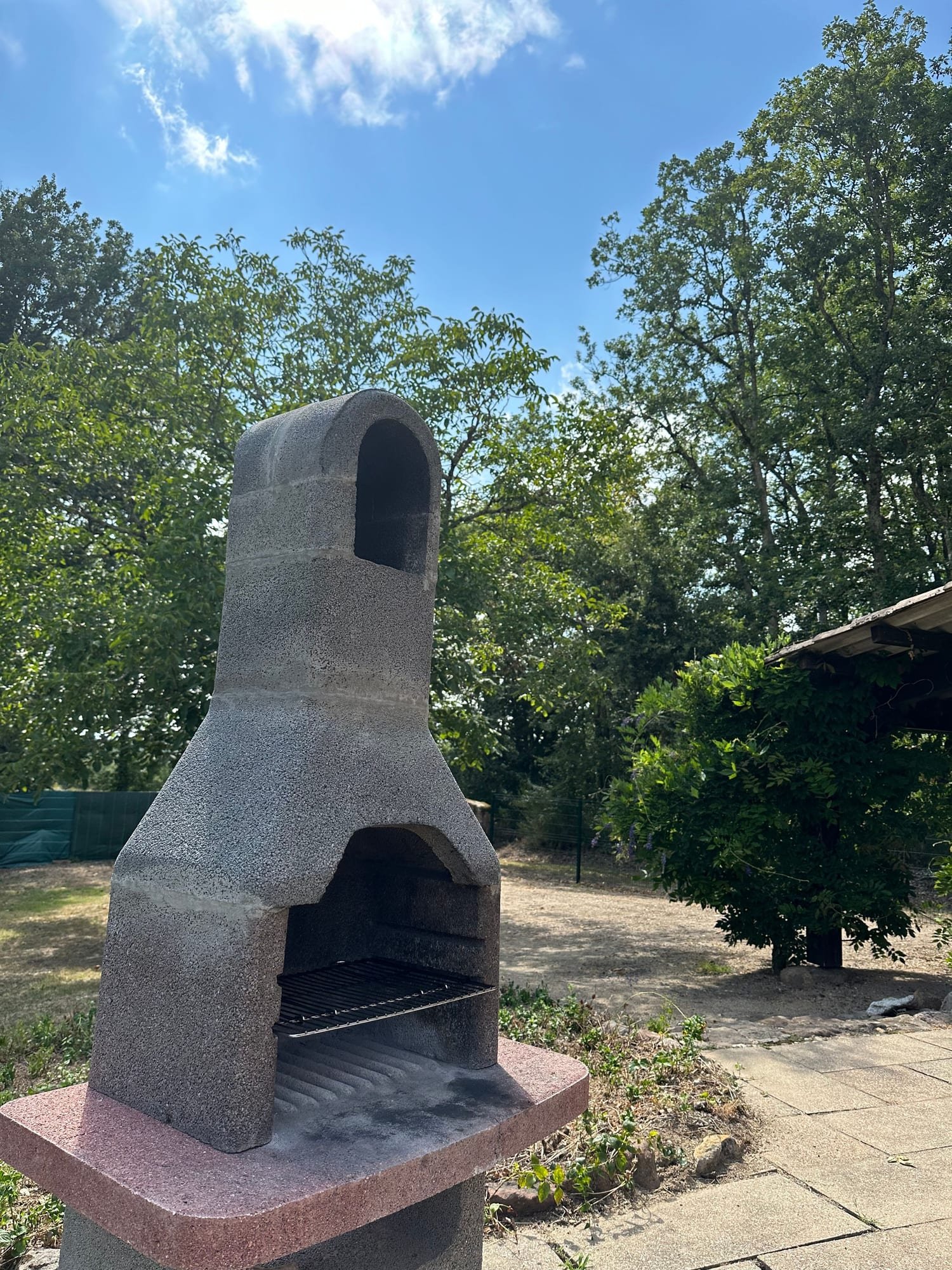 Le barbecue en pierre dans le jardin