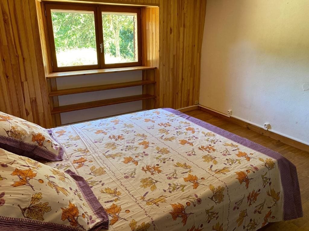 Chambre avec lit double et parure fleurie