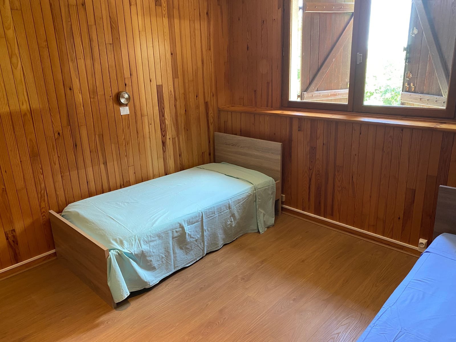 Chambre lambrissée avec lit simple