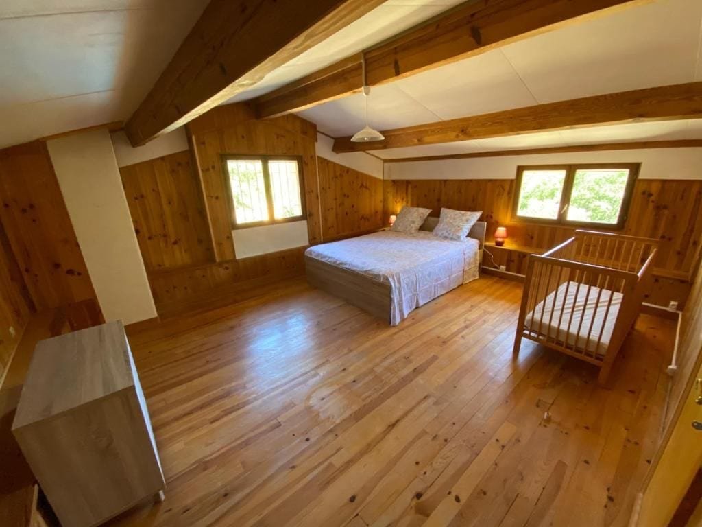 Grande chambre sous les poutres, avec lit double et lit bébé